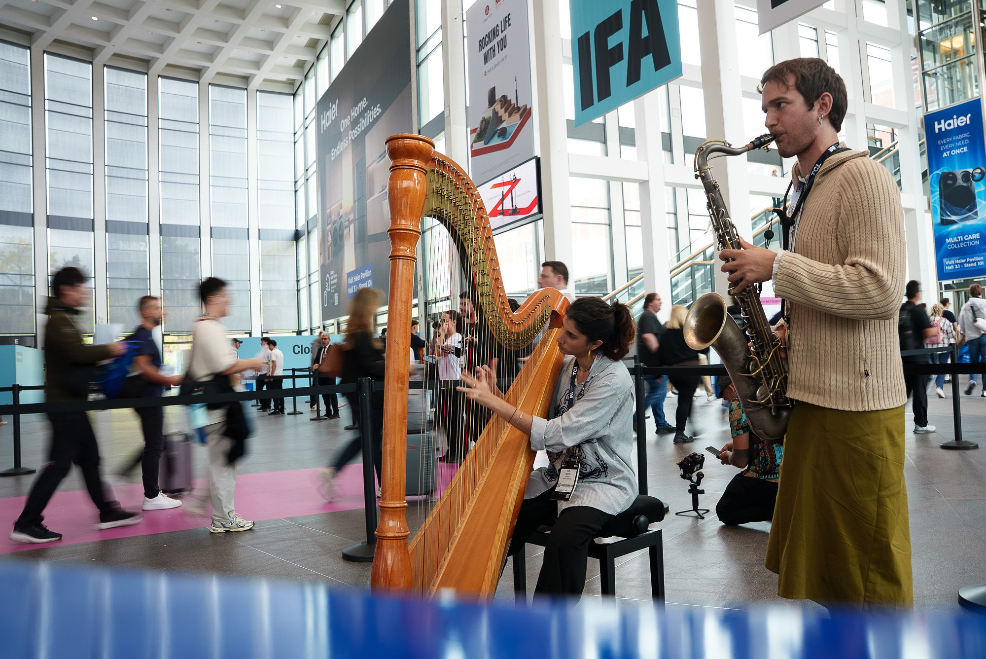 Harp and saxophone players in the IFA Berlin 2026 entrance hall.